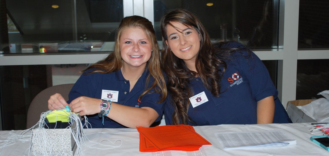 Two female students smiling at check in