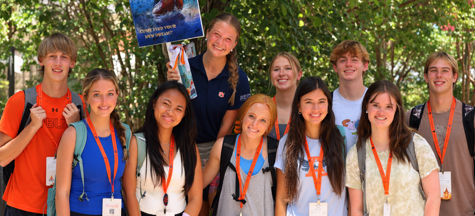 Orientation Counselor with her Camp War Eagle group of freshmen. They are all smiling at the camera. 