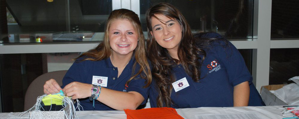 two female Orientation Leaders at check in